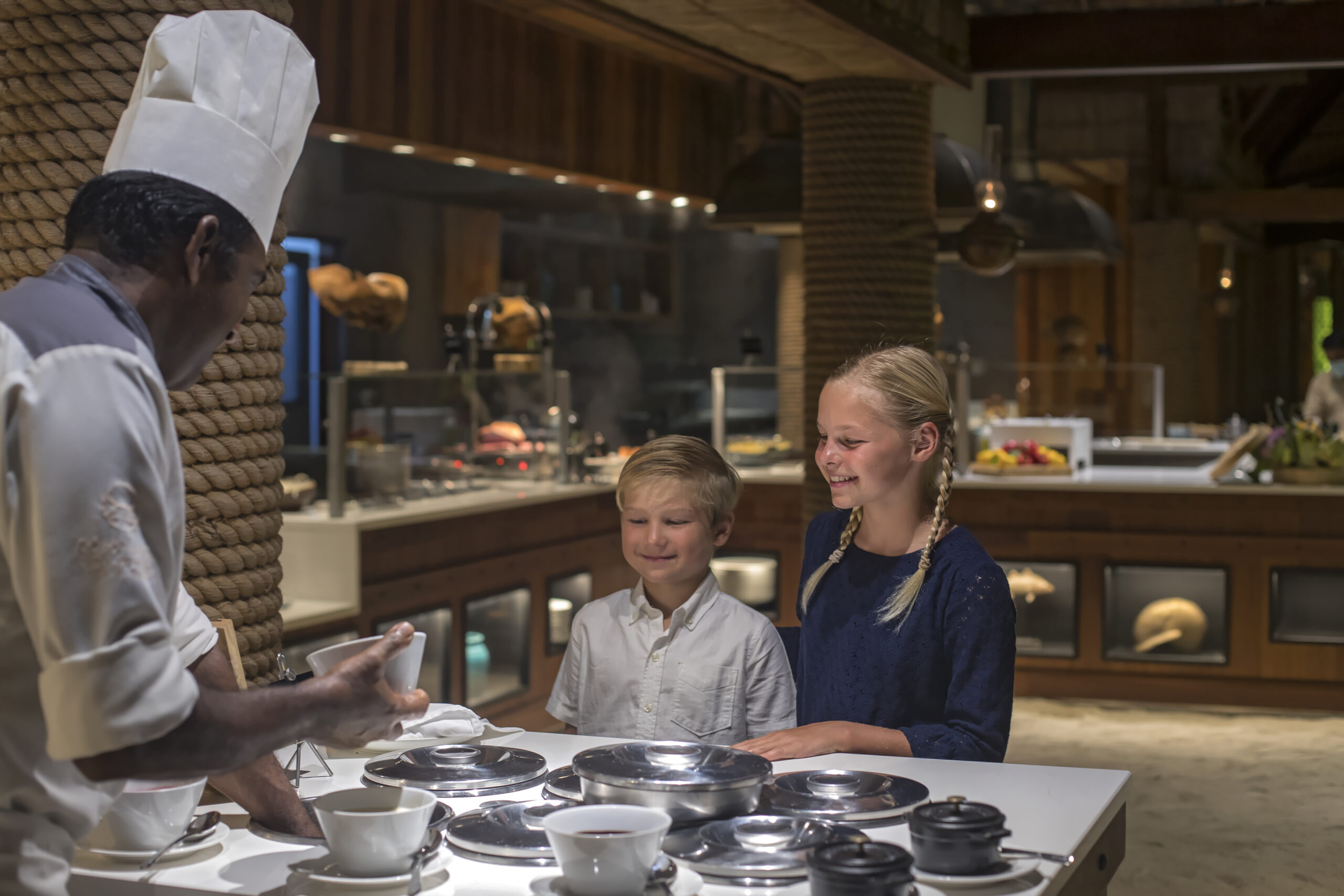 Kids interacting with chef during a cooking session at Constance Moofushi