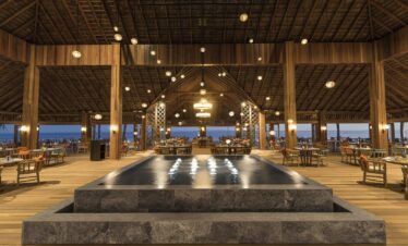 Large open air restaurant with a central water feature at Hurawalhi Island Resort