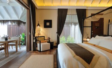 Luxurious bedroom interior at Ayada Maldives with outdoor access to a private deck