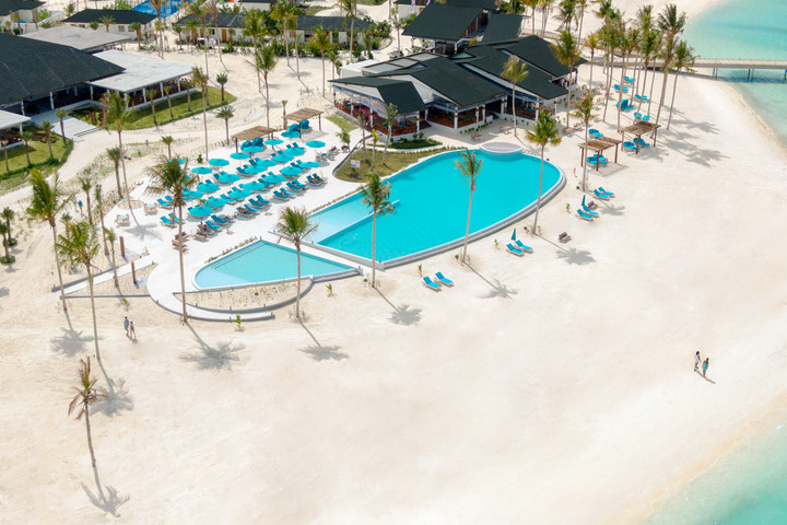 Luxurious poolside view of Joy Island with sun loungers