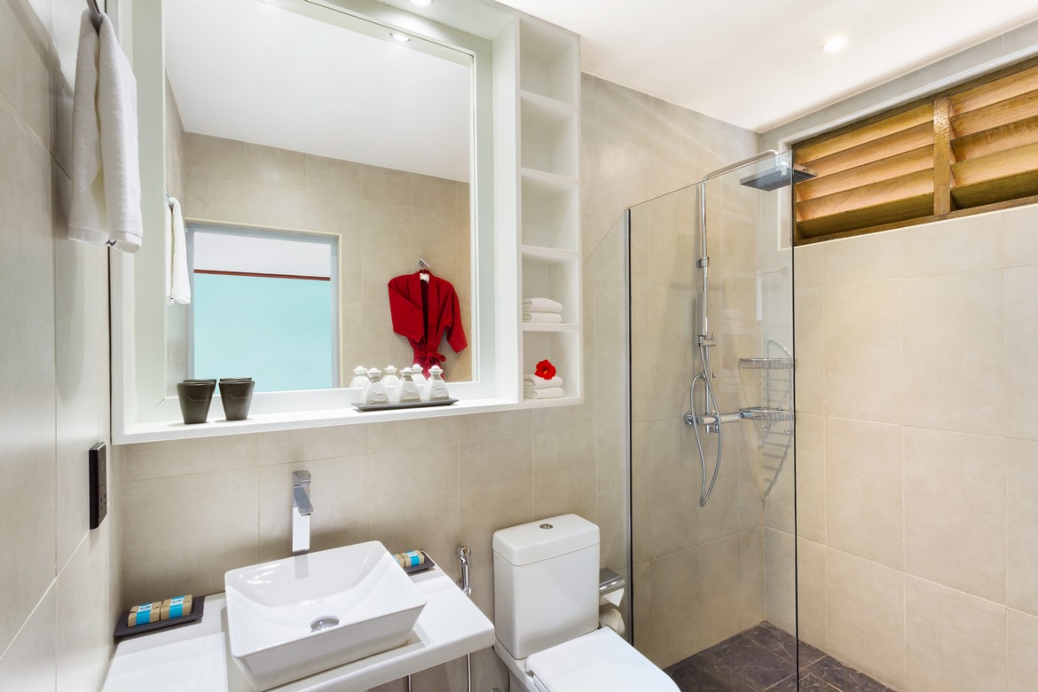 Modern bathroom at Meeru Island Resort featuring a walk in shower and minimalist design with tropical accents