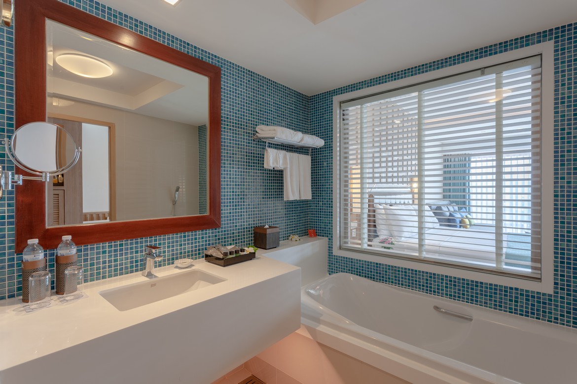 Modern bathroom with a large mirror and blue tiled walls at Diamond Cliff Resort