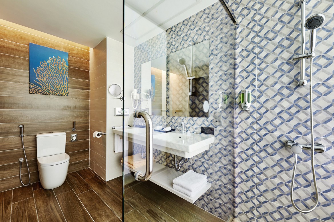 Modern bathroom with wood accents and shower at Riu Atoll