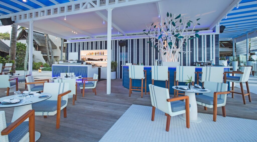 Modern open-air restaurant at Constance Belle Mare Plage with blue and white decor