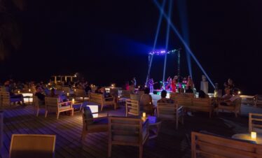 Nighttime entertainment at Vilamendhoo with guests seated under the stars enjoying live music on the deck