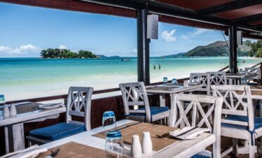 Oceanfront dining area with views of the island from Paradise Sun