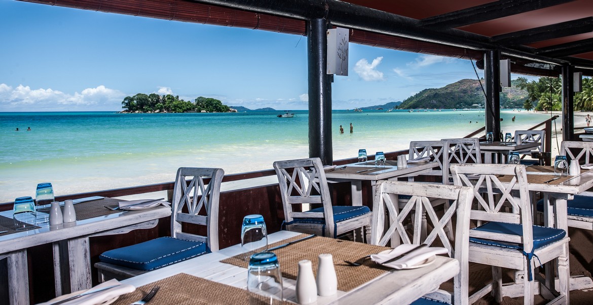 Oceanfront dining area with views of the island from Paradise Sun