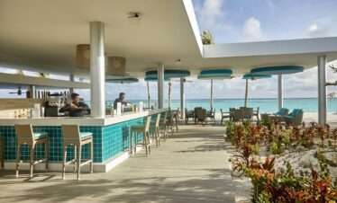 Outdoor bar area with ocean views and seating at Riu Atoll