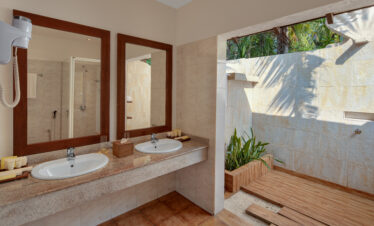 Outdoor bathroom at Adaaran Meedhupparu with twin sinks and greenery