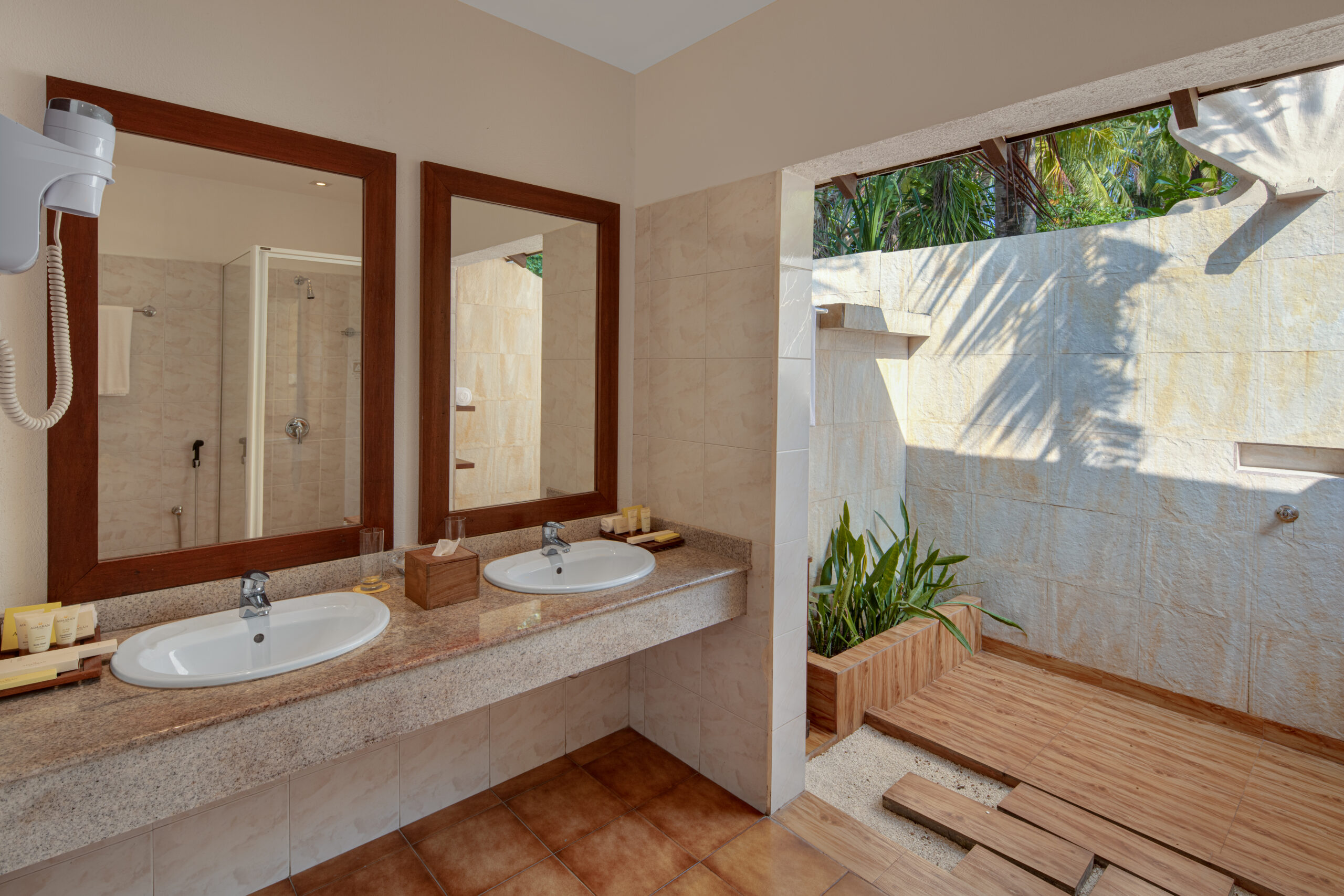 Outdoor bathroom at Adaaran Meedhupparu with twin sinks and greenery