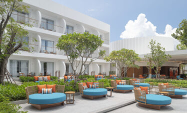 Outdoor seating area with vibrant blue cushions at Avani Chaweng Samui surrounded by greenery