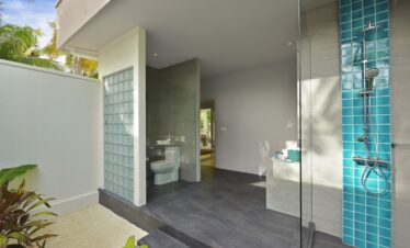 Outdoor shower area with teal tiles at Dhigali villa