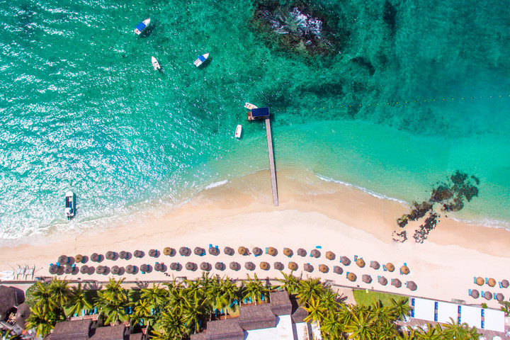 Overhead view of the turquoise lagoon and sandy beach at Constance Belle Mare Plage