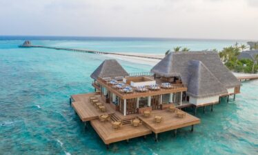 Overwater villa restaurant at Heritance Aarah with turquoise waters and an expansive wooden deck