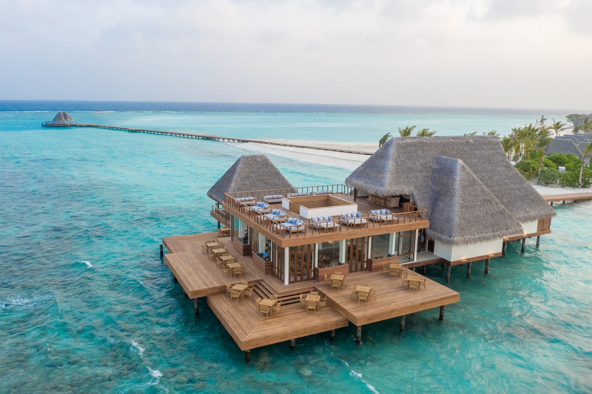 Overwater villa restaurant at Heritance Aarah with turquoise waters and an expansive wooden deck