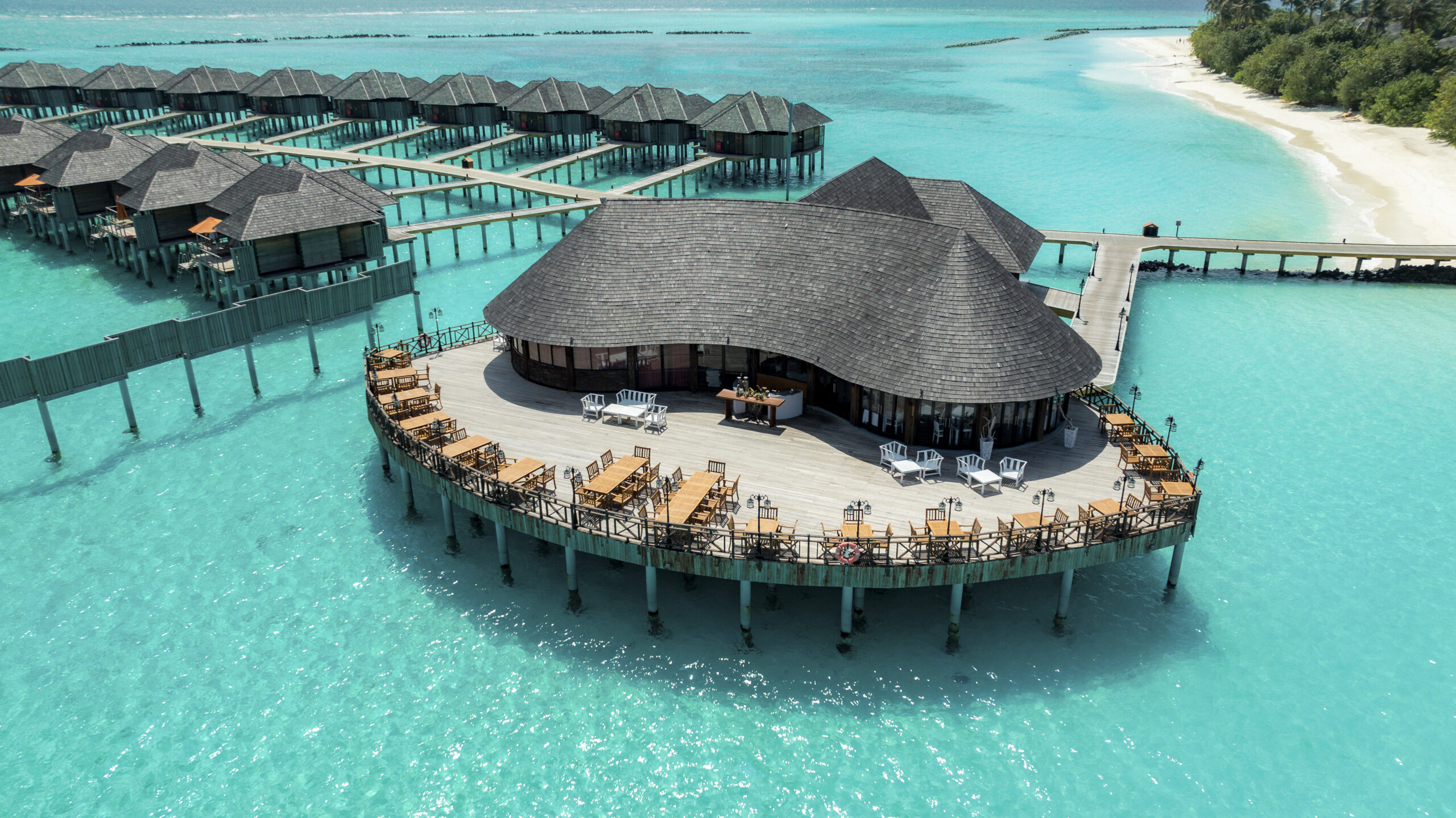 Overwater villas at Sun Siyam Iru Fushi with a stunning view of the turquoise ocean surrounding the island