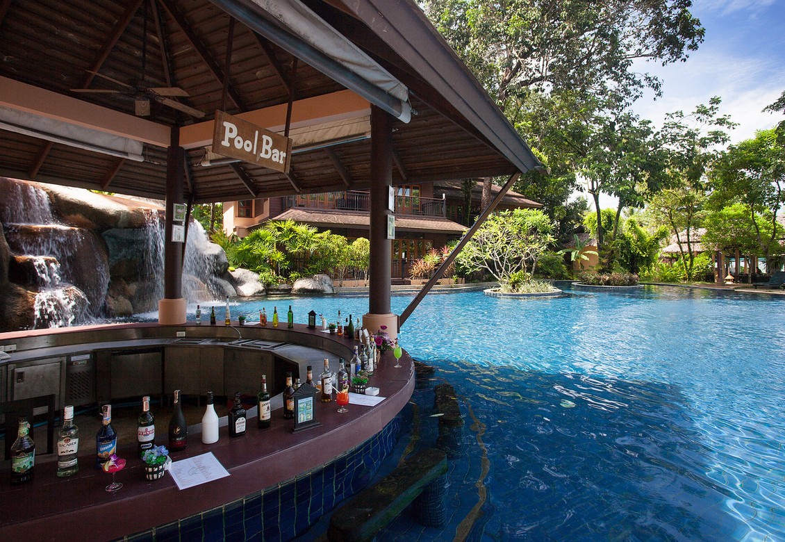 Poolside bar at Khao Lak Merlin with a view of waterfalls and tropical plants