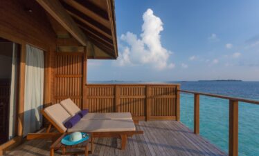 Private deck with sun loungers overlooking the ocean at Vilamendhoo perfect for relaxation and sunbathing