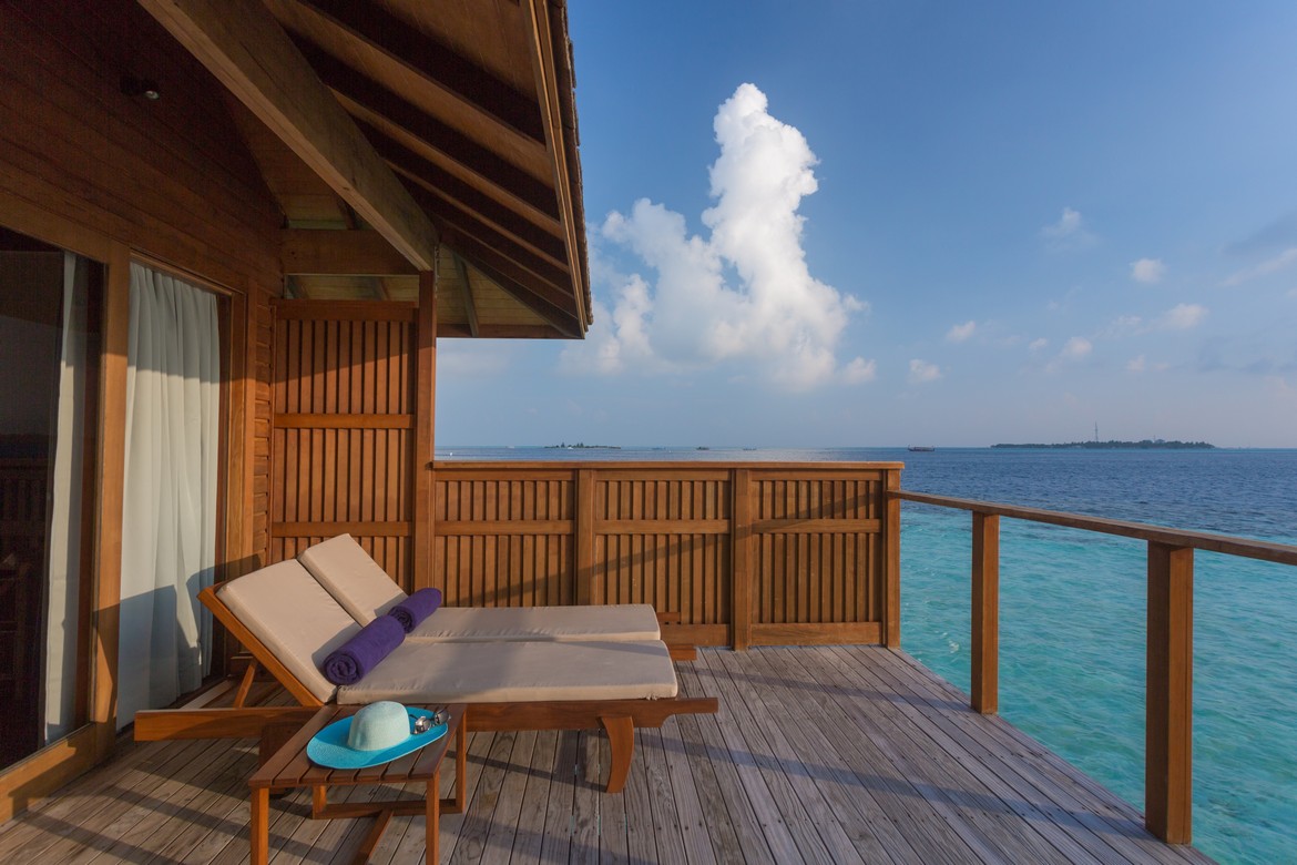 Private deck with sun loungers overlooking the ocean at Vilamendhoo perfect for relaxation and sunbathing