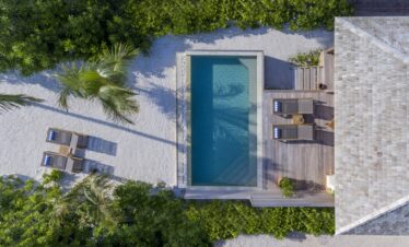 Private pool and lounge chairs surrounded by greenery at Hurawalhi Island Resort
