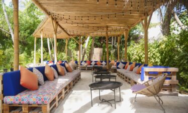 Relaxing outdoor lounge area with colorful cushions at Constance Moofushi surrounded by tropical greenery