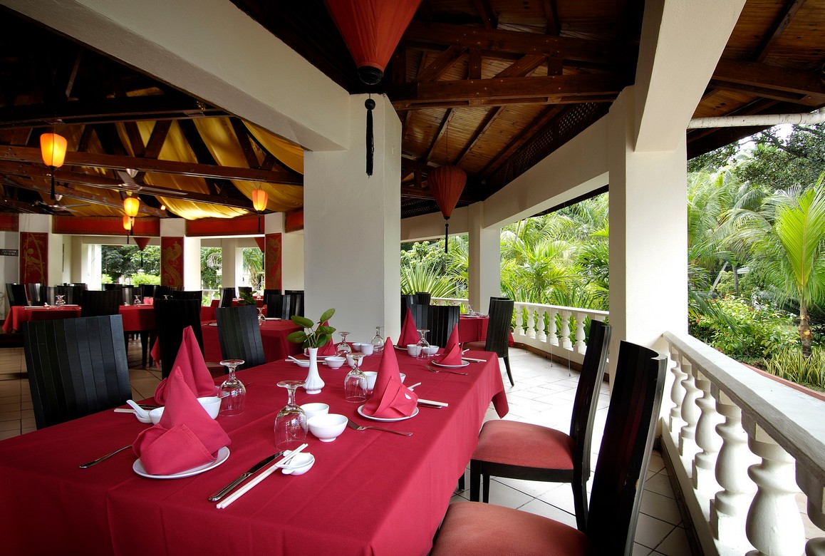 Restaurant with red tablecloths and open-air seating at Berjaya Beau Vallon
