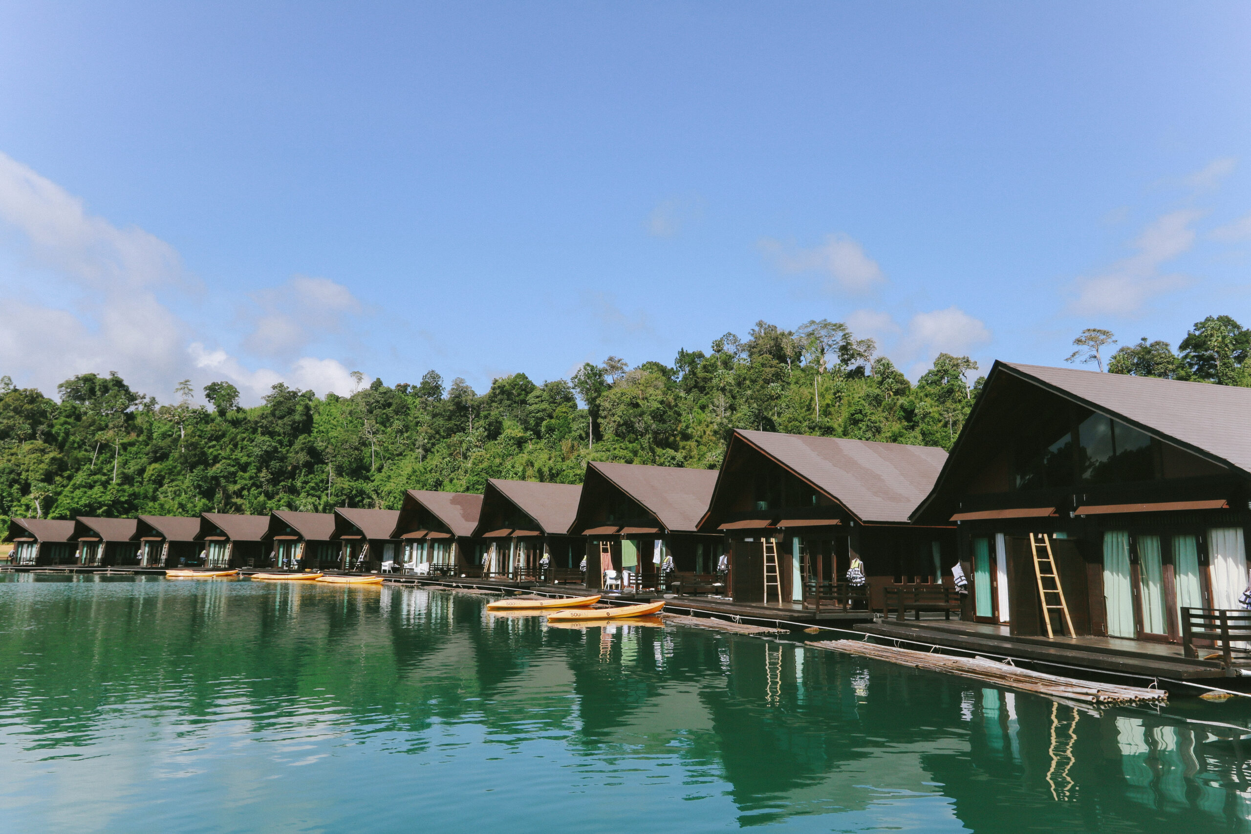 Row of floating villas reflecting on the water at 500Rai Floating Resort