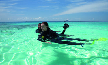 Scuba divers enjoying the clear waters at Constance Moofushi