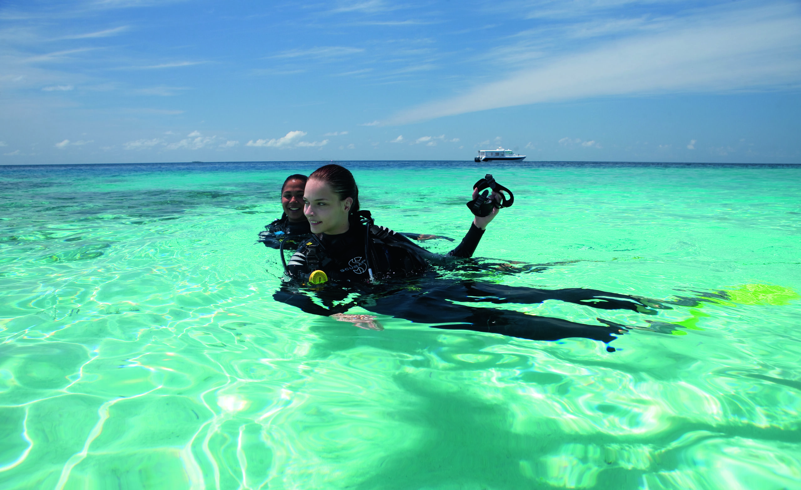 Scuba divers enjoying the clear waters at Constance Moofushi