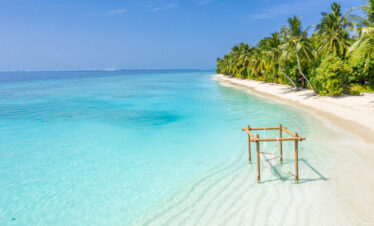 Serene beach at Ayada Maldives with a hammock floating above the clear turquoise water