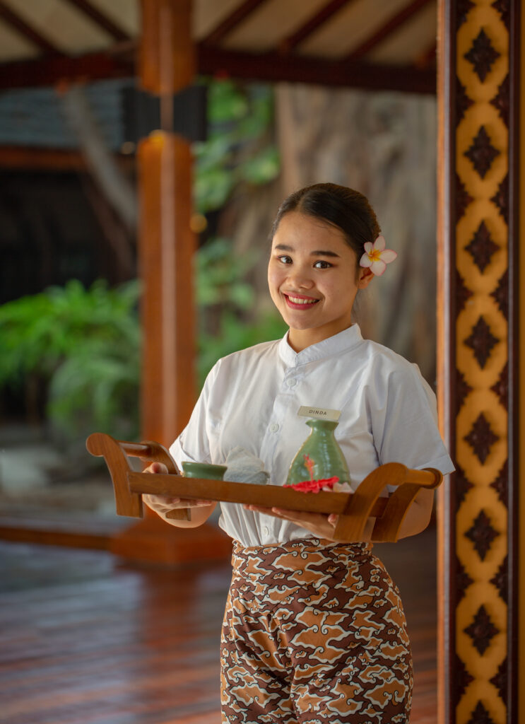 Spa staff at Adaaran Meedhupparu carrying a tray of spa essentials