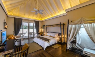 Spacious bedroom suite at Ayada Maldives featuring high ceilings and warm lighting