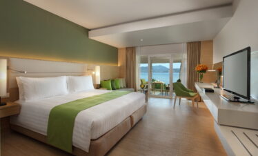 Spacious bedroom with a green theme and balcony view at Amari Phuket