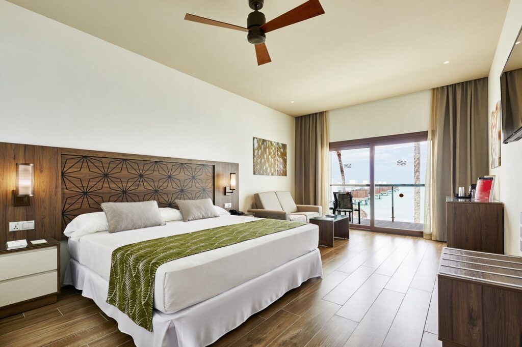 Spacious bedroom with king bed and ocean view at Riu Atoll