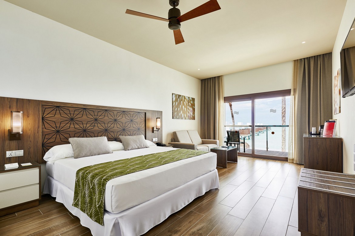 Spacious bedroom with king bed and ocean view at Riu Atoll
