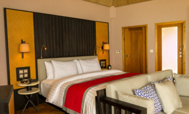 Spacious suite at Meeru Island Resort with a modern design featuring a king size bed and stylish wooden accents