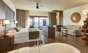 Spacious suite with ocean view and modern decor at Riu Palace