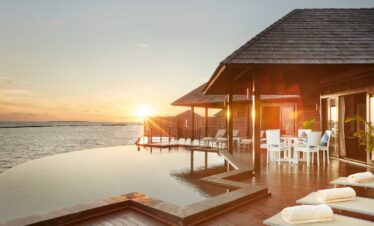 Sun Siyam Iru Fushi sunset view from an overwater villa with a private infinity pool overlooking the ocean