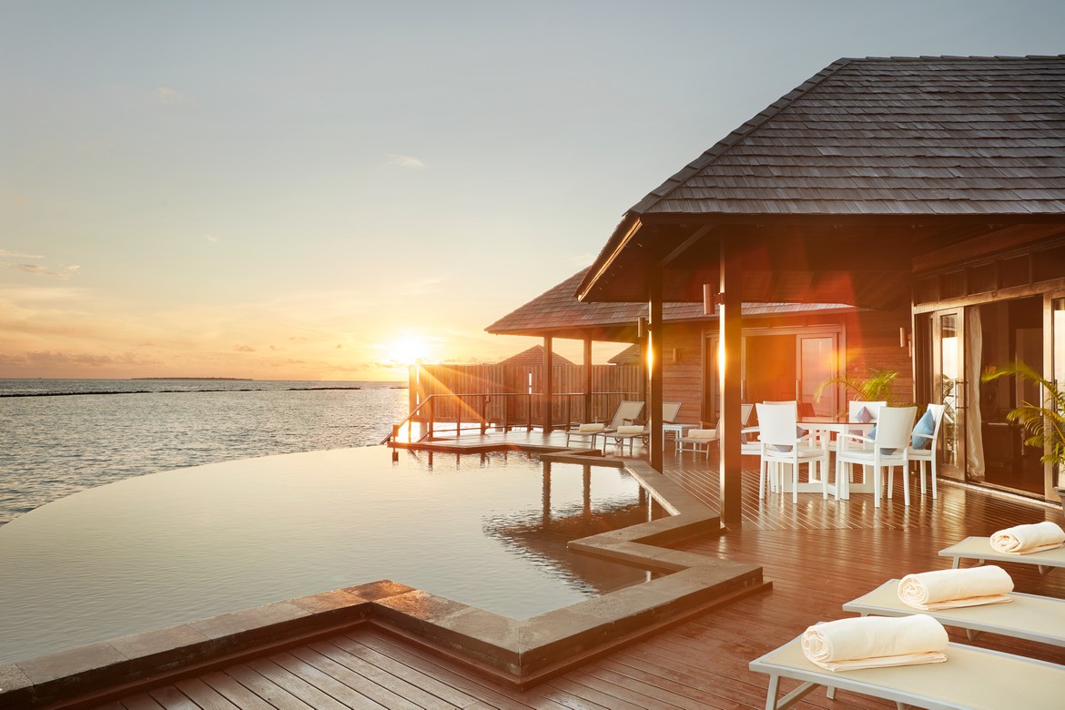 Sun Siyam Iru Fushi sunset view from an overwater villa with a private infinity pool overlooking the ocean