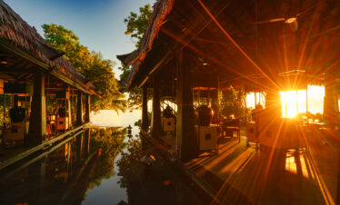 Sun setting over serene reflection pool at Ayada Maldives surrounded by tropical foliage