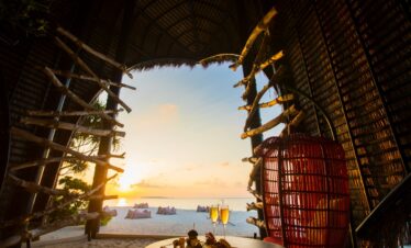 Sunset view from Dhigali beach hut with food and drinks on the table