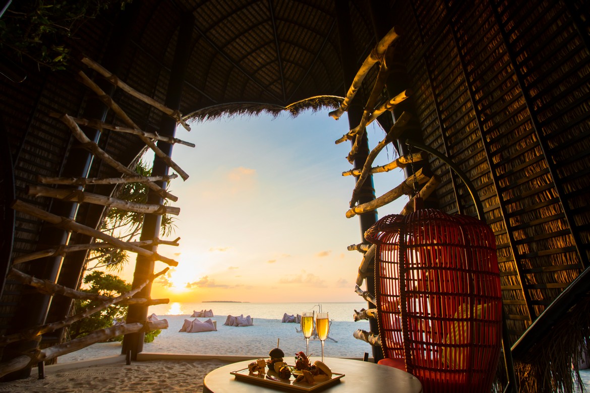 Sunset view from Dhigali beach hut with food and drinks on the table