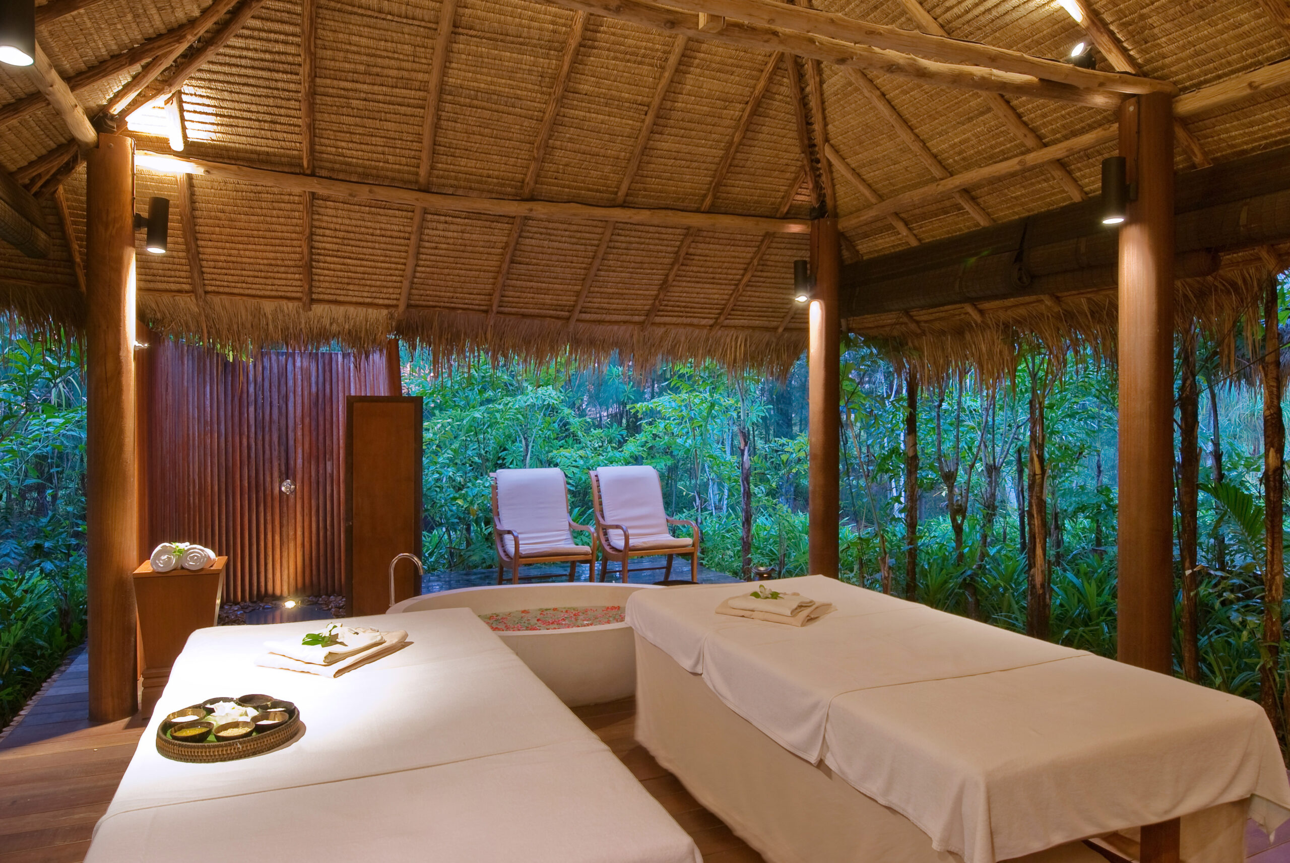 The Sarojin Khao Lak open-air spa room with nature views and treatment tables in a tranquil setting