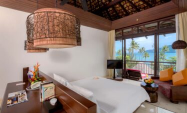 The Vijitt Resort bedroom with ocean view and modern decor featuring natural materials