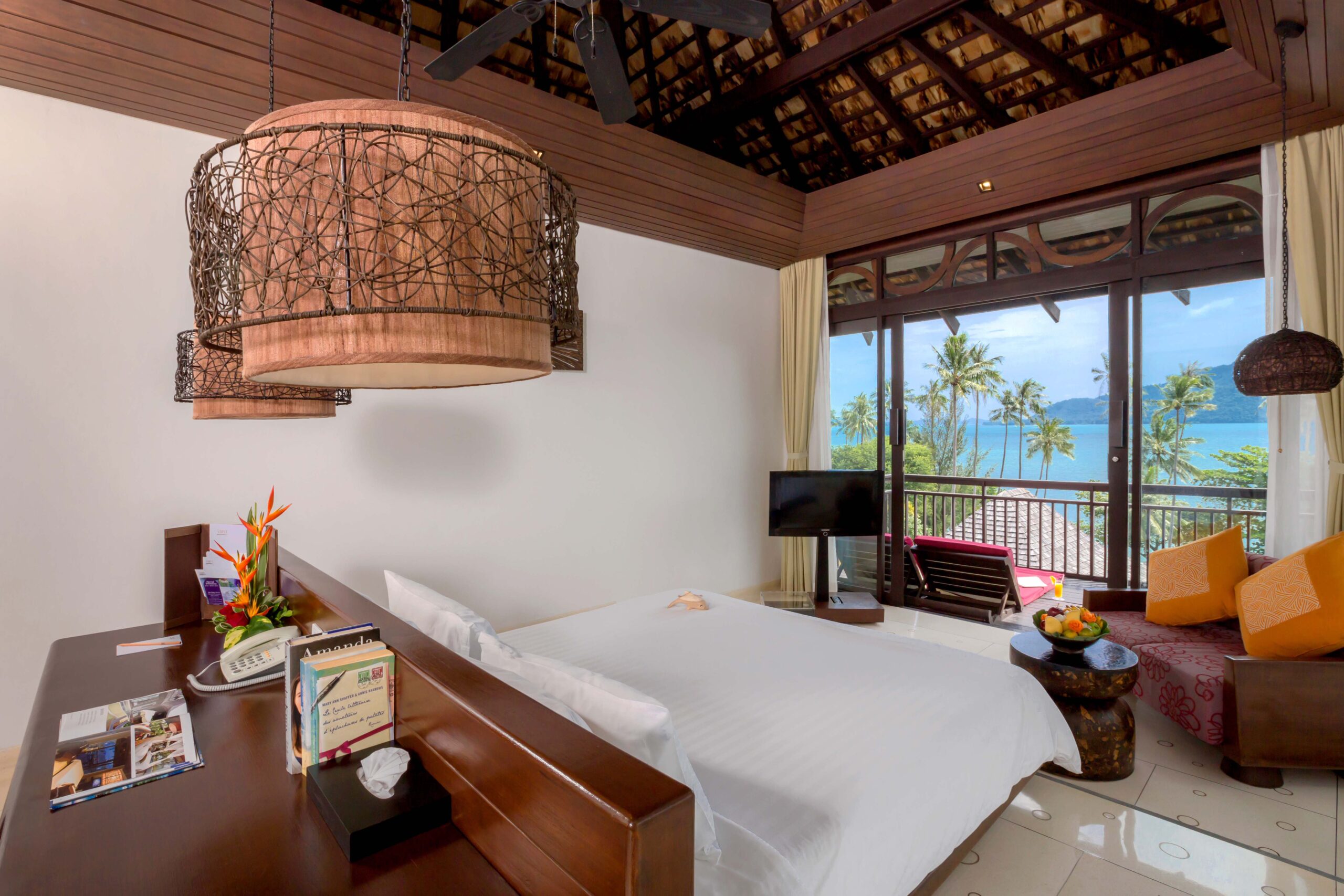 The Vijitt Resort bedroom with ocean view and modern decor featuring natural materials