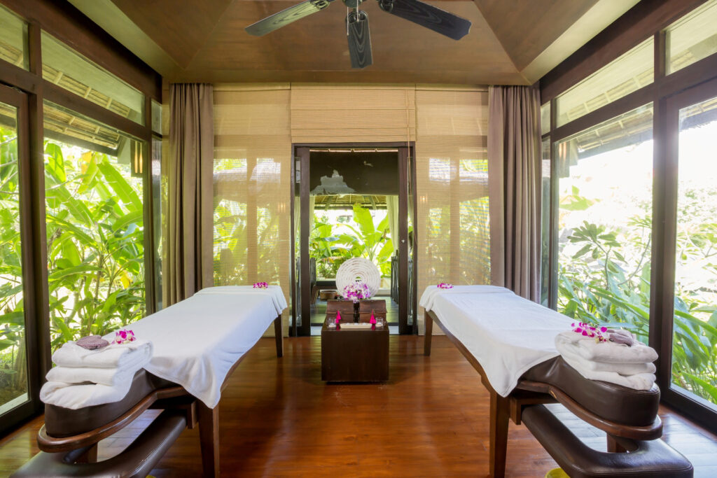 The Vijitt Resort spa treatment room with two massage tables surrounded by lush greenery