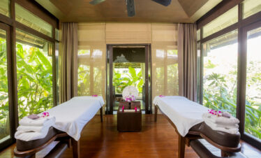The Vijitt Resort spa treatment room with two massage tables surrounded by lush greenery