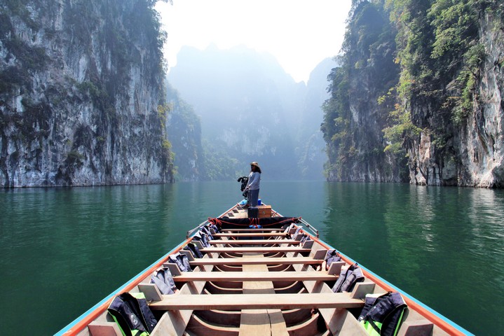 Tourist on a boat exploring cliffs and calm waters near 500Rai Floating Resort