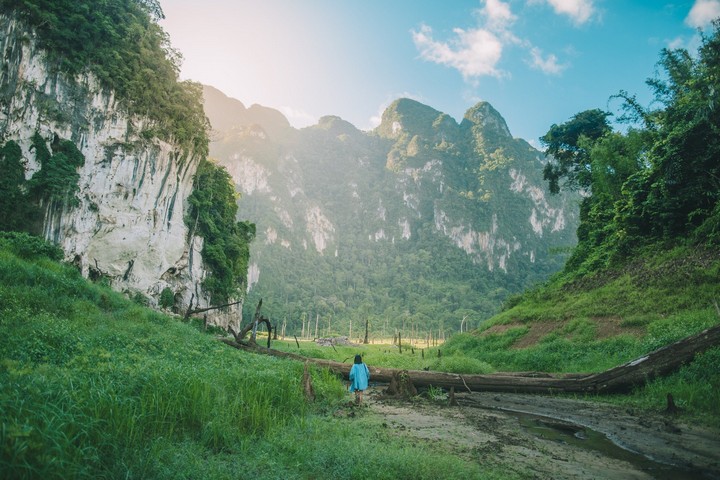 Tourist walking through lush valley near cliffs close to 500Rai Floating Resort