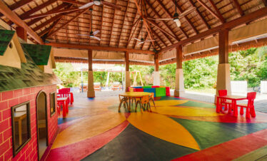 Vibrant kids play area at Ayada Maldives with colorful tables chairs and a thatched roof
